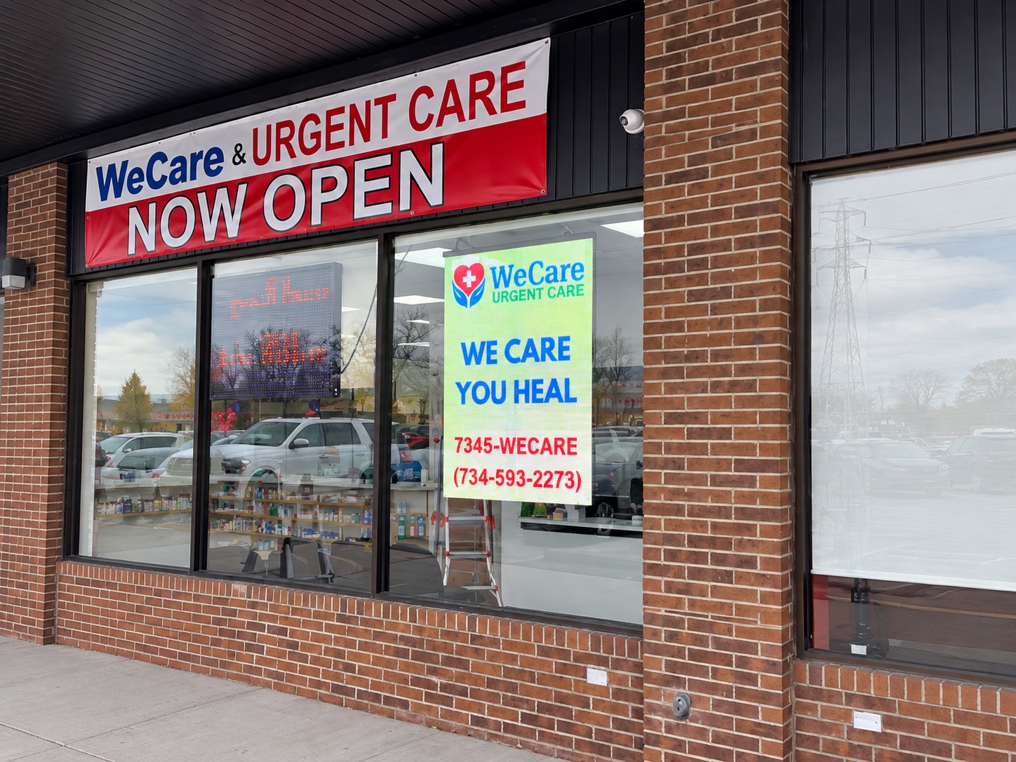 Wide storefront view of the WeCare Urgent Care transparent LED display in Trenton